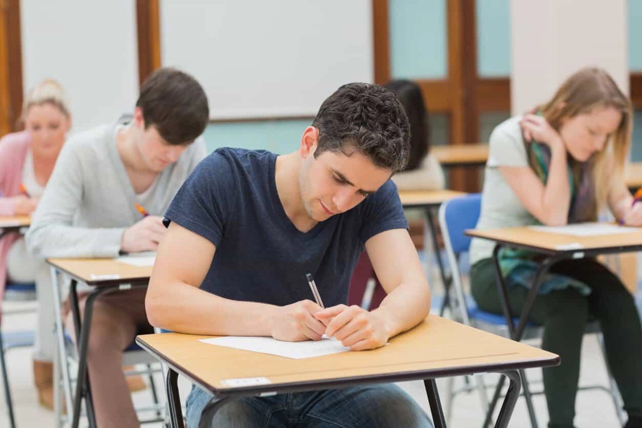 Candidates seated at desks writing an examination